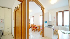 A spacious kitchen with wooden cabinets, a dining area with chairs, and a small island with a sink.