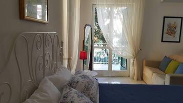 Camera quadrupla (BLU) | Una scrivania, tende oscuranti, ferro/asse da stiro