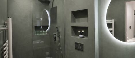 A modern bathroom with a glass-enclosed shower, a toilet, and a vanity with a sink.