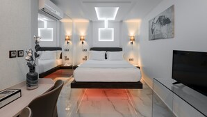 A modern hotel room with a bed, bedside lamps, a flat-screen TV, and a large painting on the wall. - Athens Starlight Hotel (Athens)