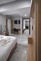 Una habitación de hotel moderna con cama, escritorio y televisor.