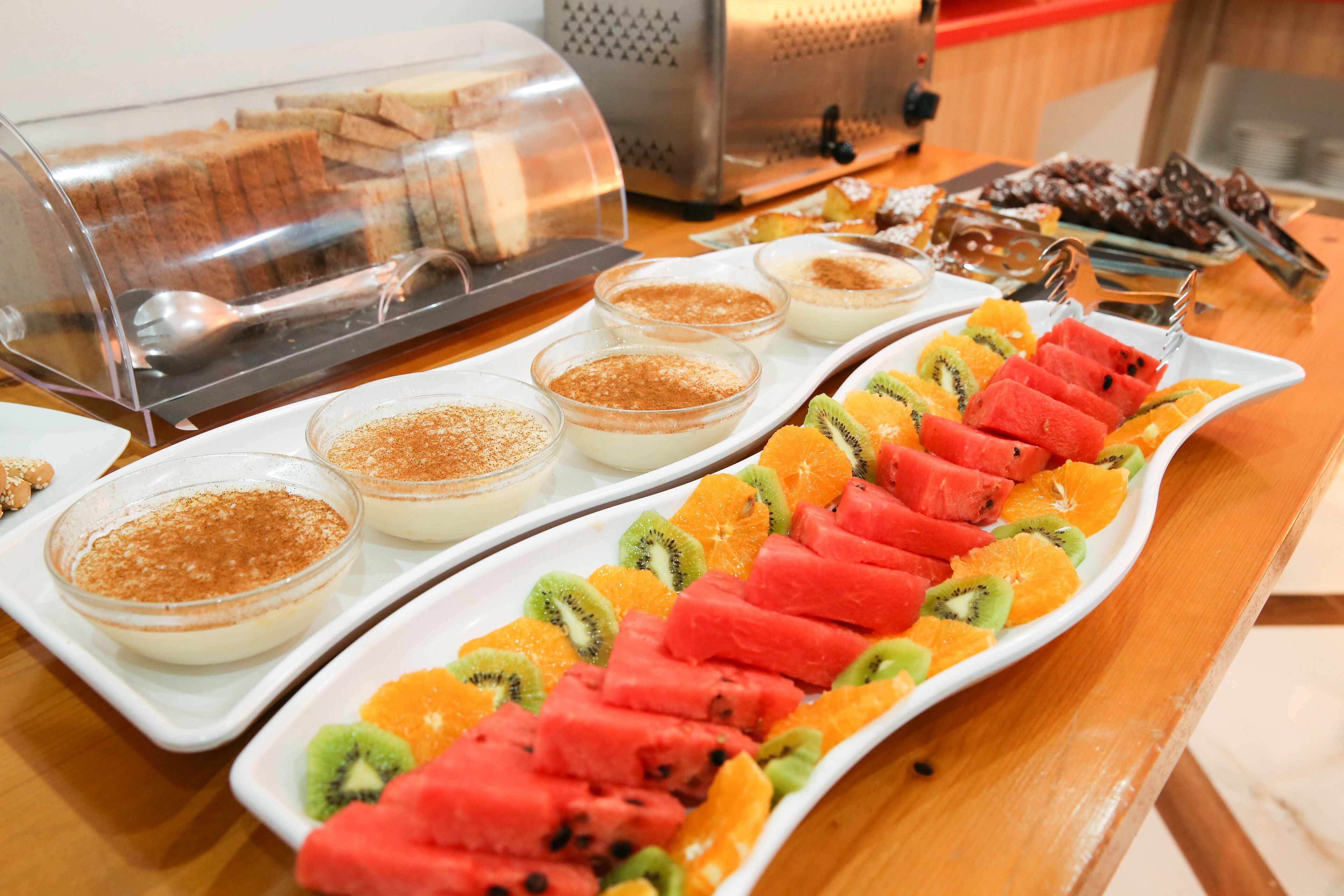 A buffet with various desserts and fruit.
