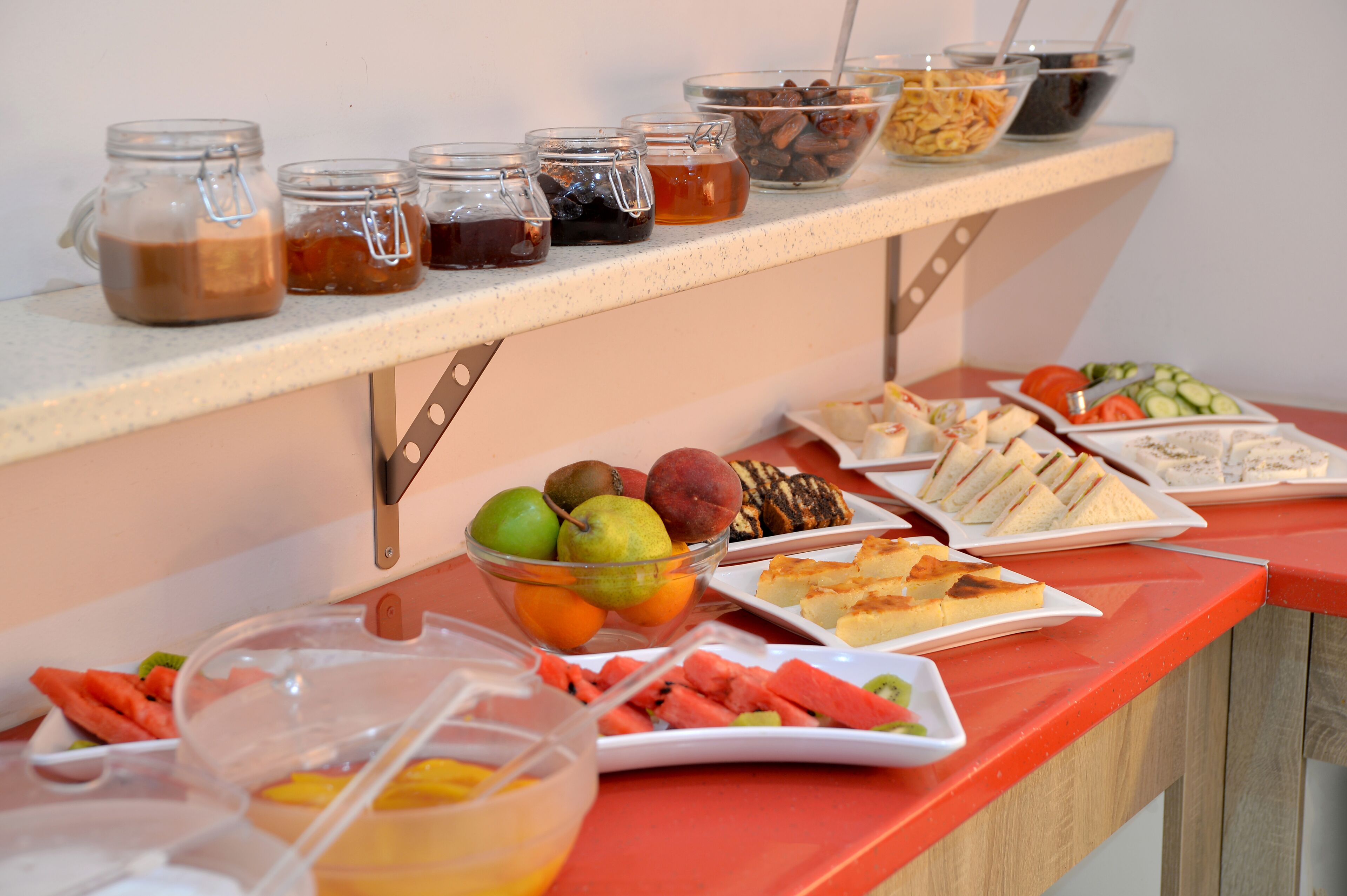 A buffet table with various food items and condiments.
