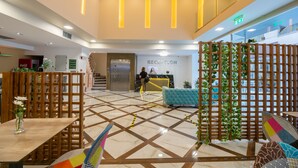 A hotel reception area with a reception desk, a staircase, and a seating area with a patterned floor. - Athens Starlight Hotel (Athens)
