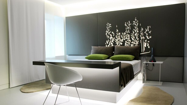 A modern bedroom with a bed, bedside table, chair, and decorative wall panel. - Quinta das Lavandeiras - Caldas de Vizela (Vizela)