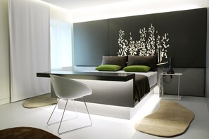 Une chambre moderne comprenant un lit, une table de chevet, une chaise et un panneau décoratif mural.