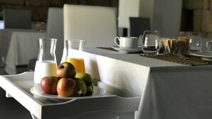 A breakfast setup with a tray of fruits, a glass of milk, and a glass of orange juice on a table. - Quinta das Lavandeiras - Caldas de Vizela (Vizela)