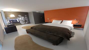 Un dormitorio moderno con una cama grande, una mesita de noche y una lámpara de pared.