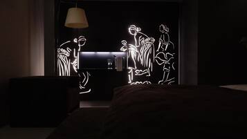 Un dormitorio moderno con cama, mesita de noche y lámpara de pared.