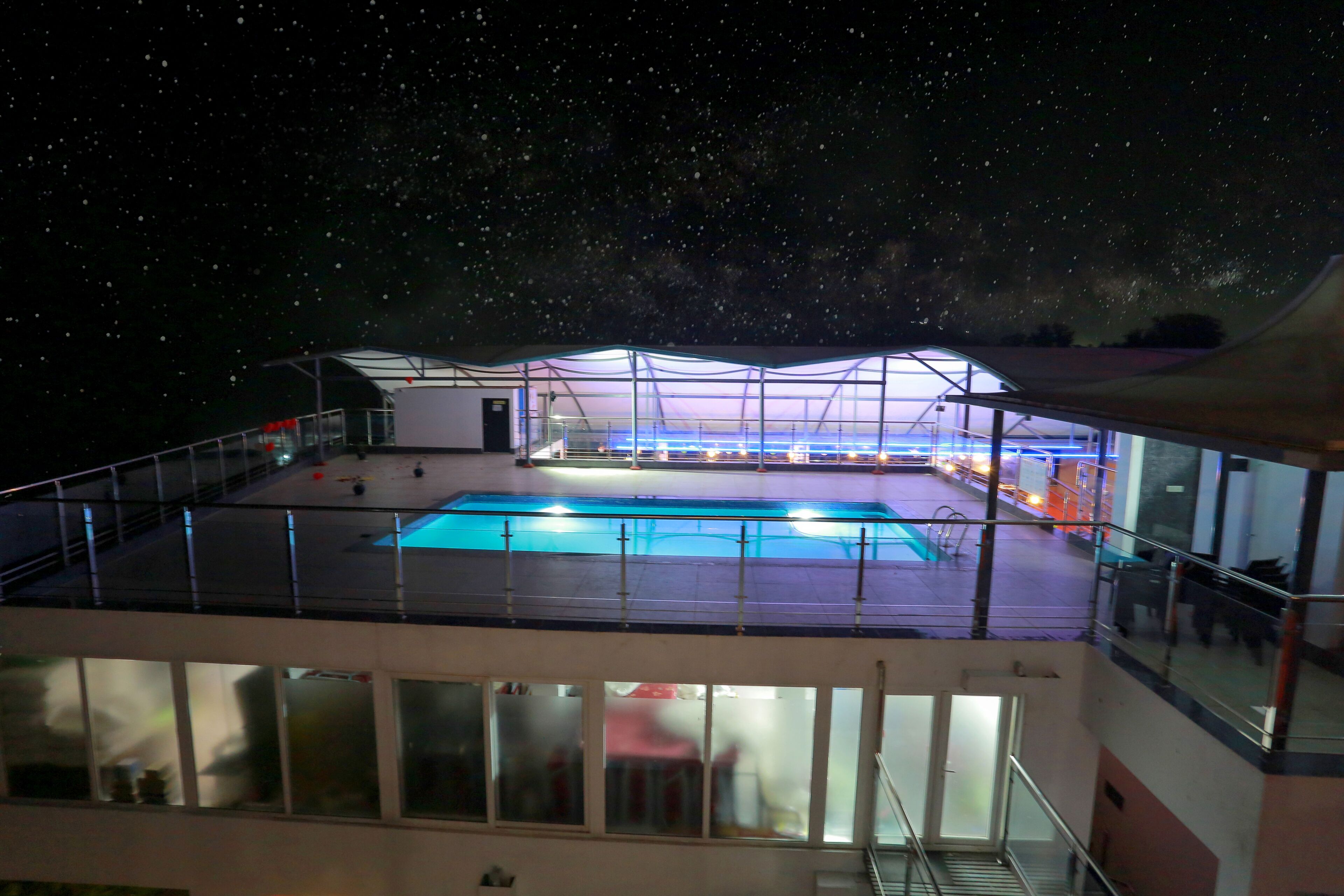 A rooftop pool area with a clear view of the night sky.