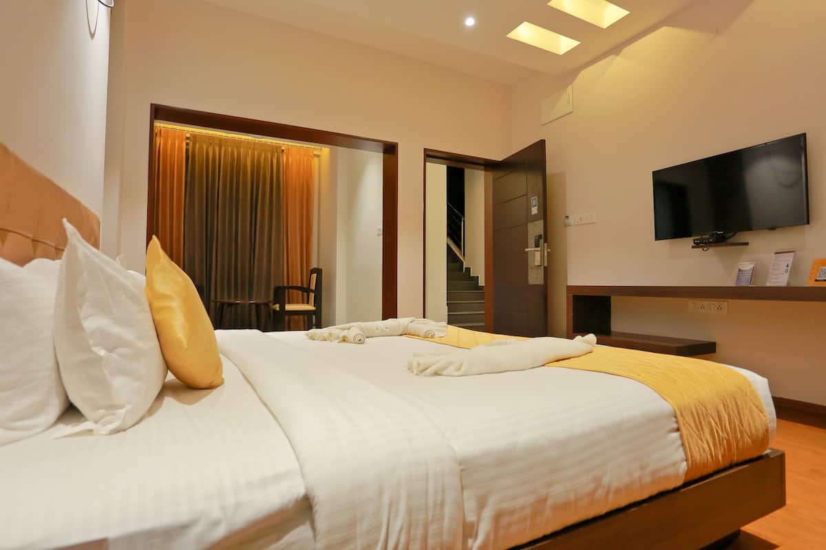 Una habitación de hotel con una cama, una televisión y una escalera que lleva a un piso superior.