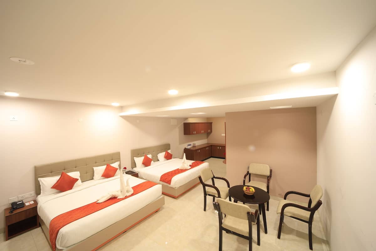 Habitación de hotel con dos camas, una mesa de comedor y una kitchenette.