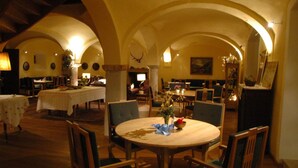 A spacious dining area with high arched ceilings and multiple tables and chairs. - Romantik Hotel Zum Klosterbräu (Neuburg)
