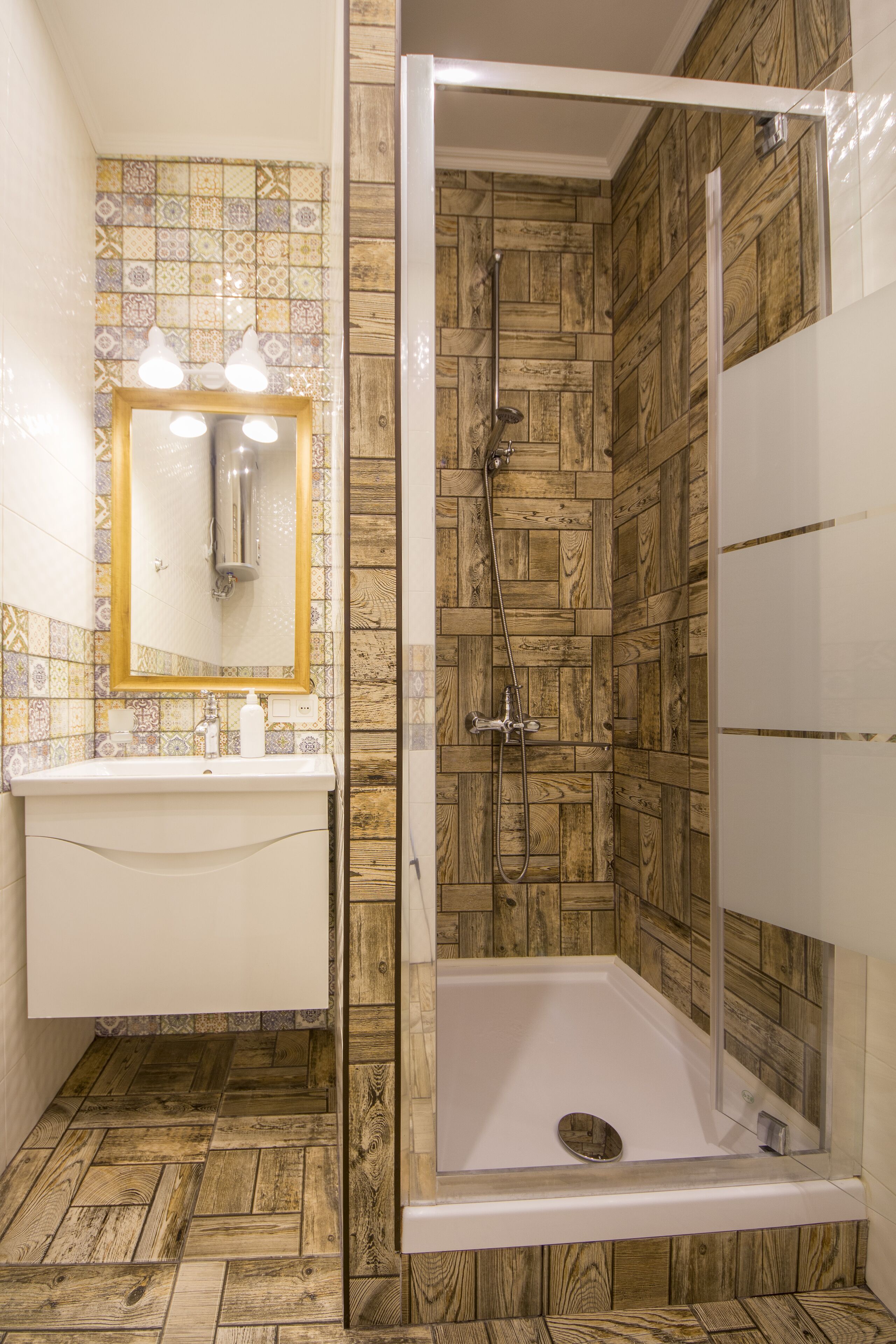 Un baño con pared de madera, un lavabo con espejo y un box de ducha.