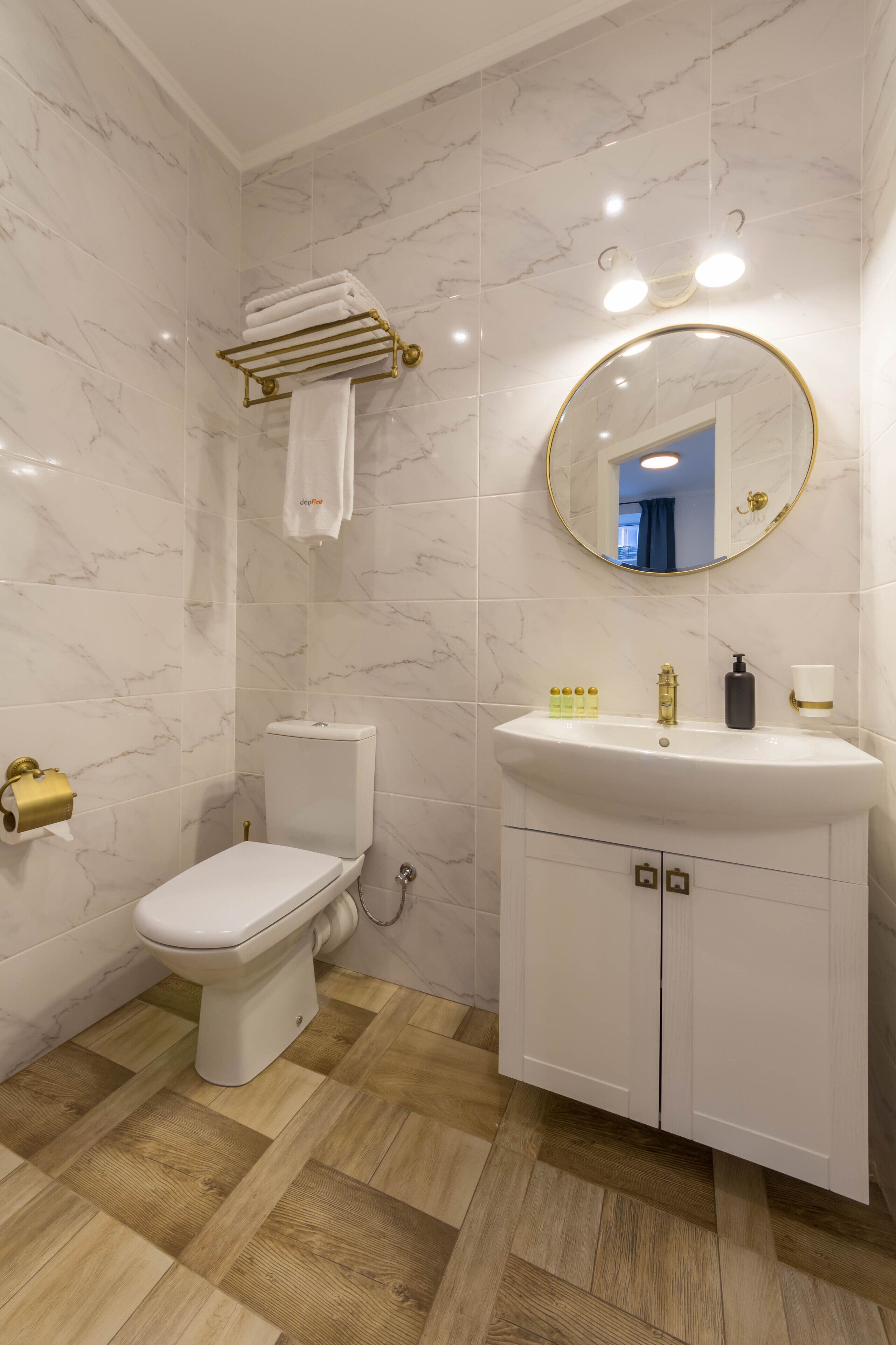 A bathroom with a toilet, sink, and mirror.