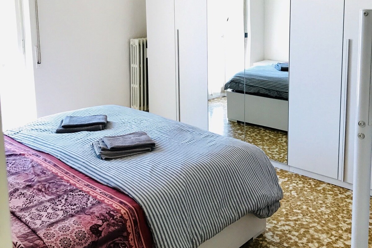 Une chambre à coucher avec un lit, une armoire et un miroir.