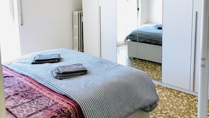 Une chambre à coucher avec un lit, une armoire et un miroir.