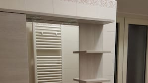 A bathroom with a white sink, a mirror, and a toilet. There is a green trash bin next to the toilet. - Agata (Cocullo)