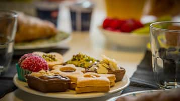 A plate of assorted pastries and a glass of water on a table.
