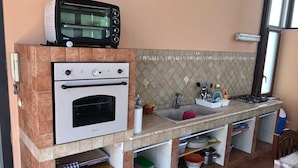 A compact kitchen with a built-in oven, a toaster, a sink, and storage cabinets. - Calatafimi House Casa Vacanze Palermo (Palermo)