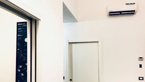 A hallway with a white door, a radiator, and a white table. - Humanitas (Milan)