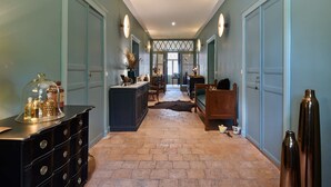 A hallway with a central island, a sofa, and a wooden bench. - Bel Air Maison D'hôtes des Landes (Castets)
