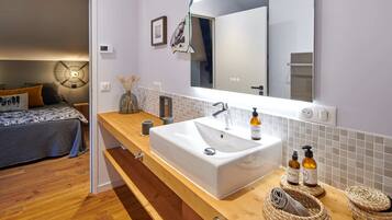 Une salle de bain moderne avec un grand lavabo, un miroir et un meuble-lavabo en bois.