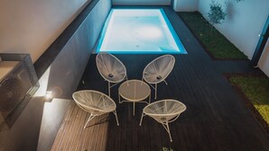A modern outdoor patio with a glass-top table and four wicker chairs. - Bom JardimApartments (Porto)