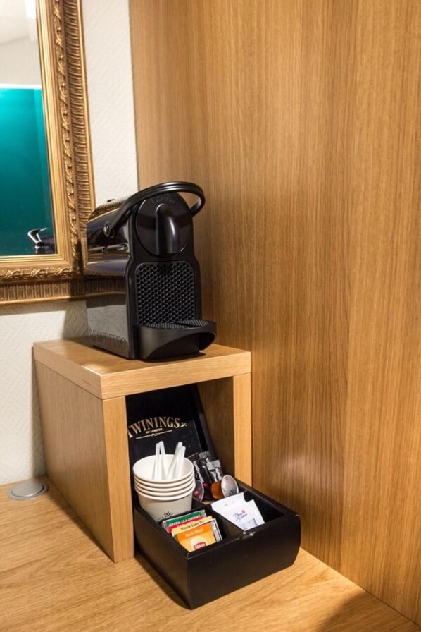A coffee station with a coffee maker, a tray with cups, a spoon, and a book. - Senja Hotell (Senja)