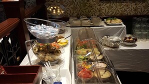 Una barra de buffet con diversos alimentos y salsas.