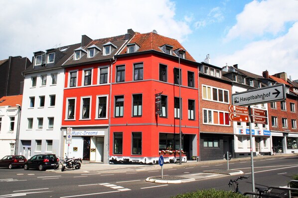 Ein rotes und weißes Gebäude mit einem Schild für 'Music Dreams' und einem Hinweisschild für 'Hauptbahnhof'.