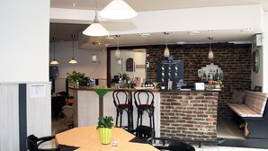 A modern hotel lobby with a brick wall, a reception desk, and seating areas. - Hotel Klenkes am Bahnhof (Aachen)