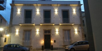 Un edificio de dos pisos con balcones y una entrada central.