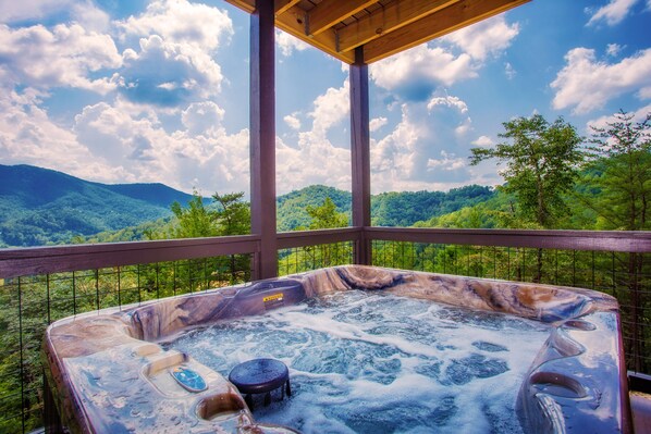 A hot tub with a view of a mountainous landscape.