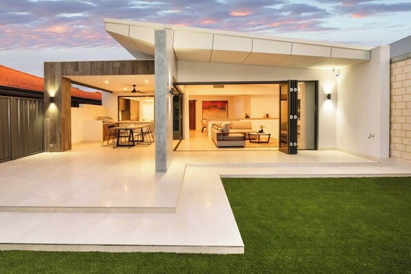 A modern house with a patio, a dining area, and a living room.