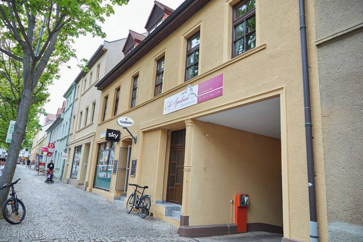 A street with buildings, a bicycle, and a sign for 'City Apartments'.