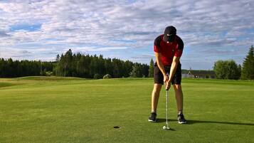 Una persona en un campo de golf a punto de hacer un putt.
