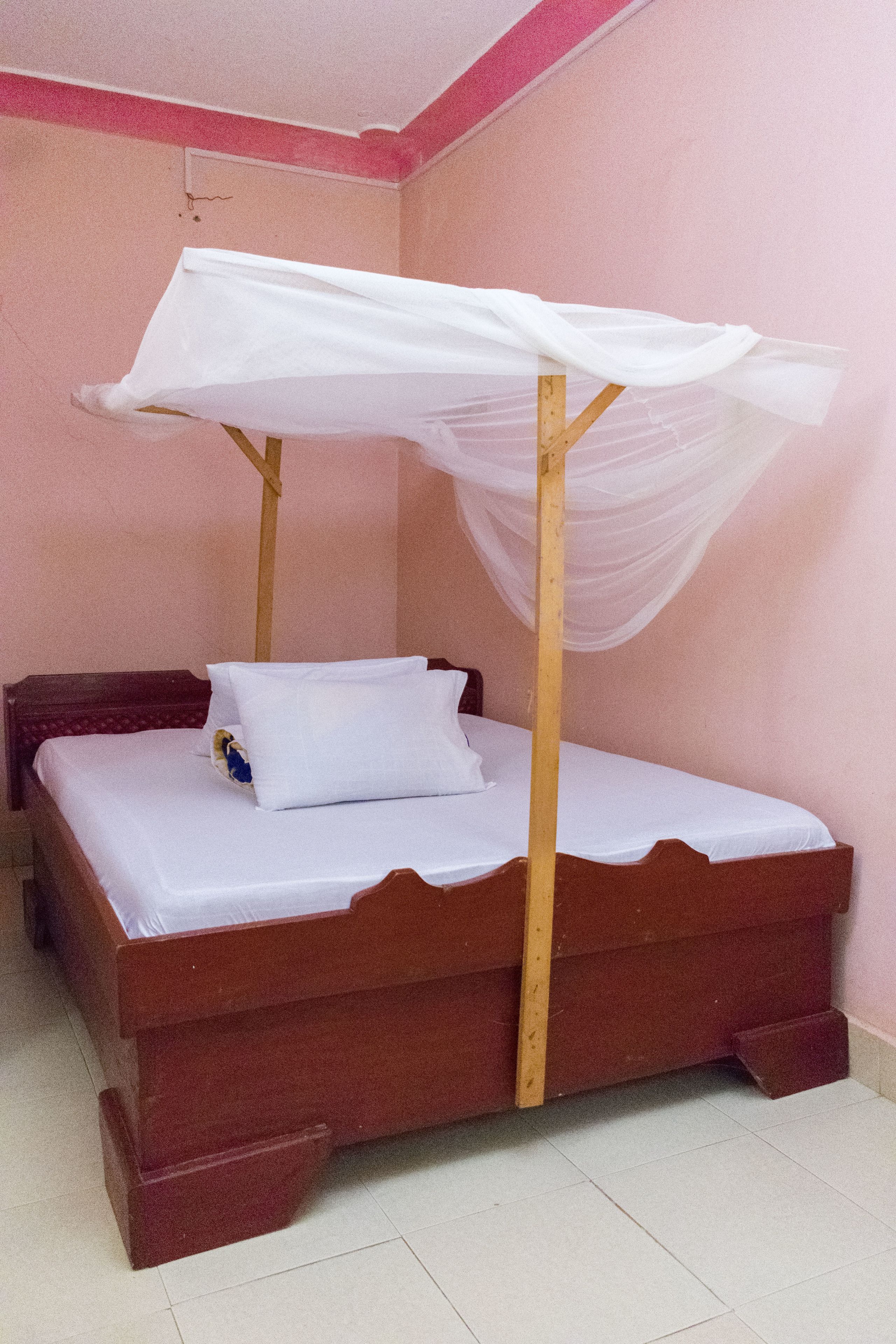 Una cama de madera individual con dosel, una almohada y una colcha.