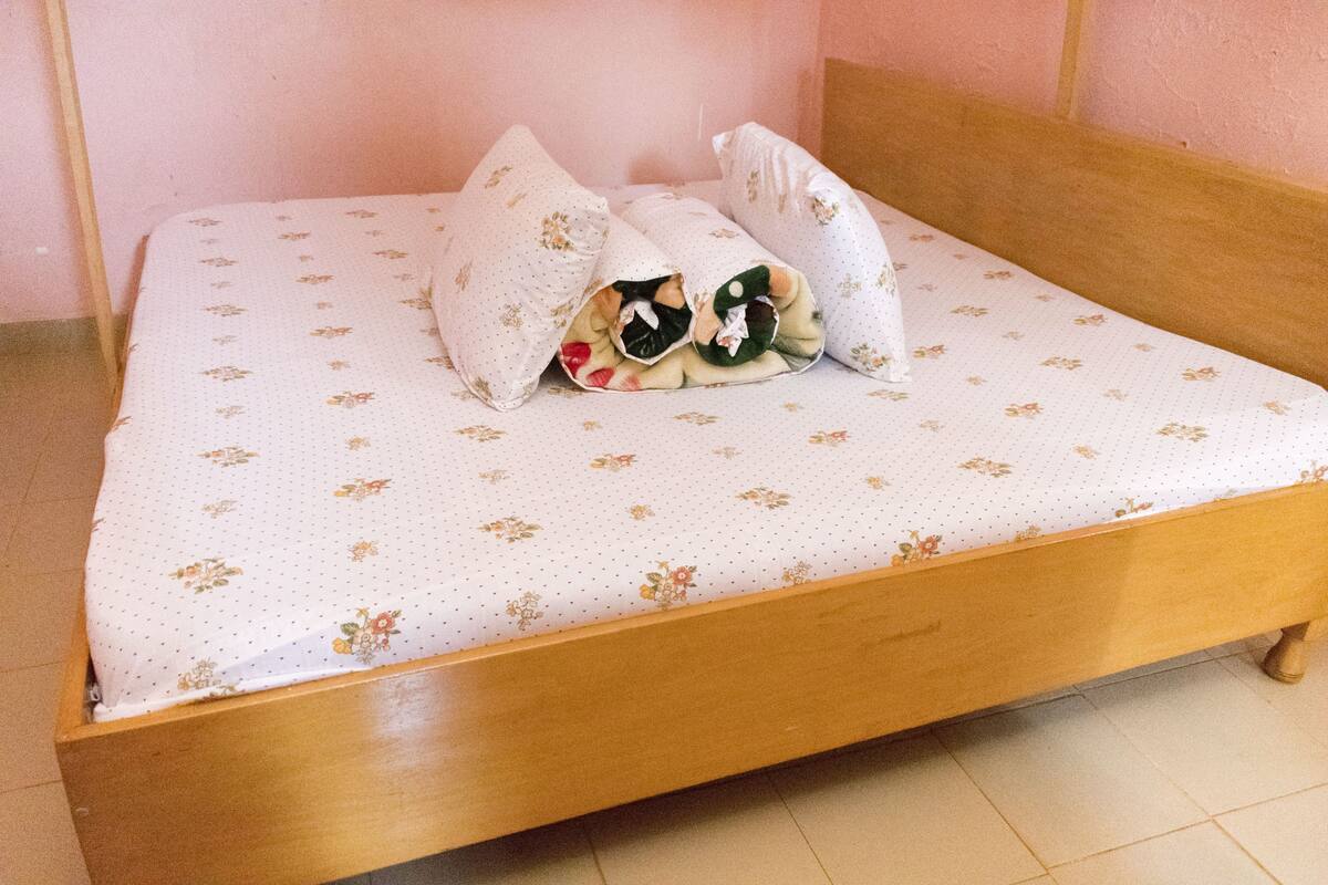 A bed with a floral-patterned bedspread and pillows.
