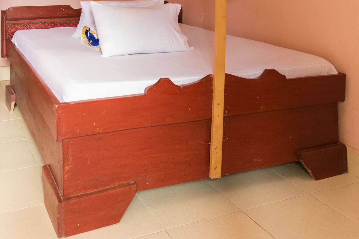 A single bed with a wooden frame and a canopy.