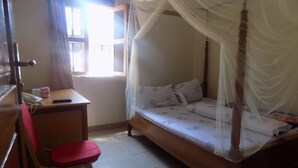 Un dormitorio con una cama individual, un escritorio y una silla.