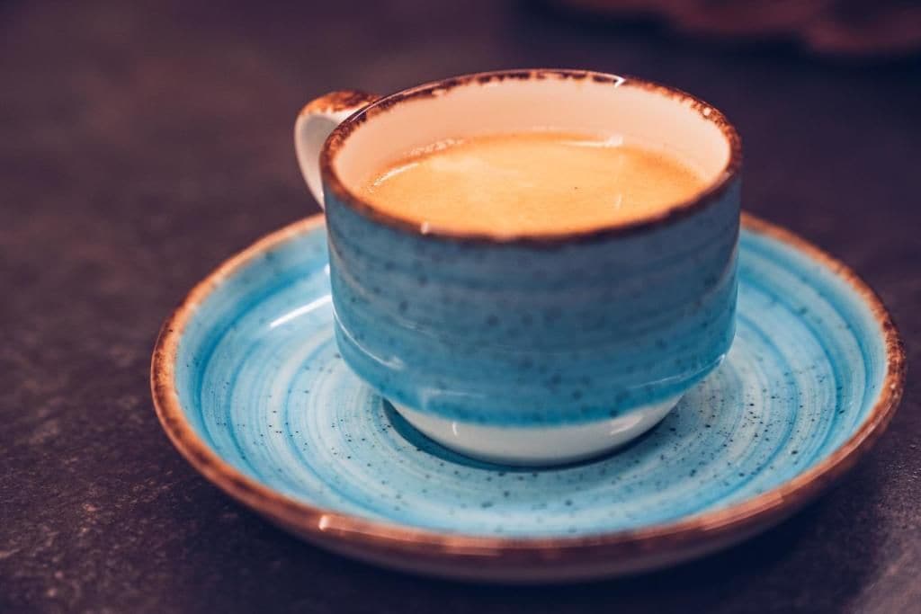 Una taza de cerámica con asa sobre un platillo.