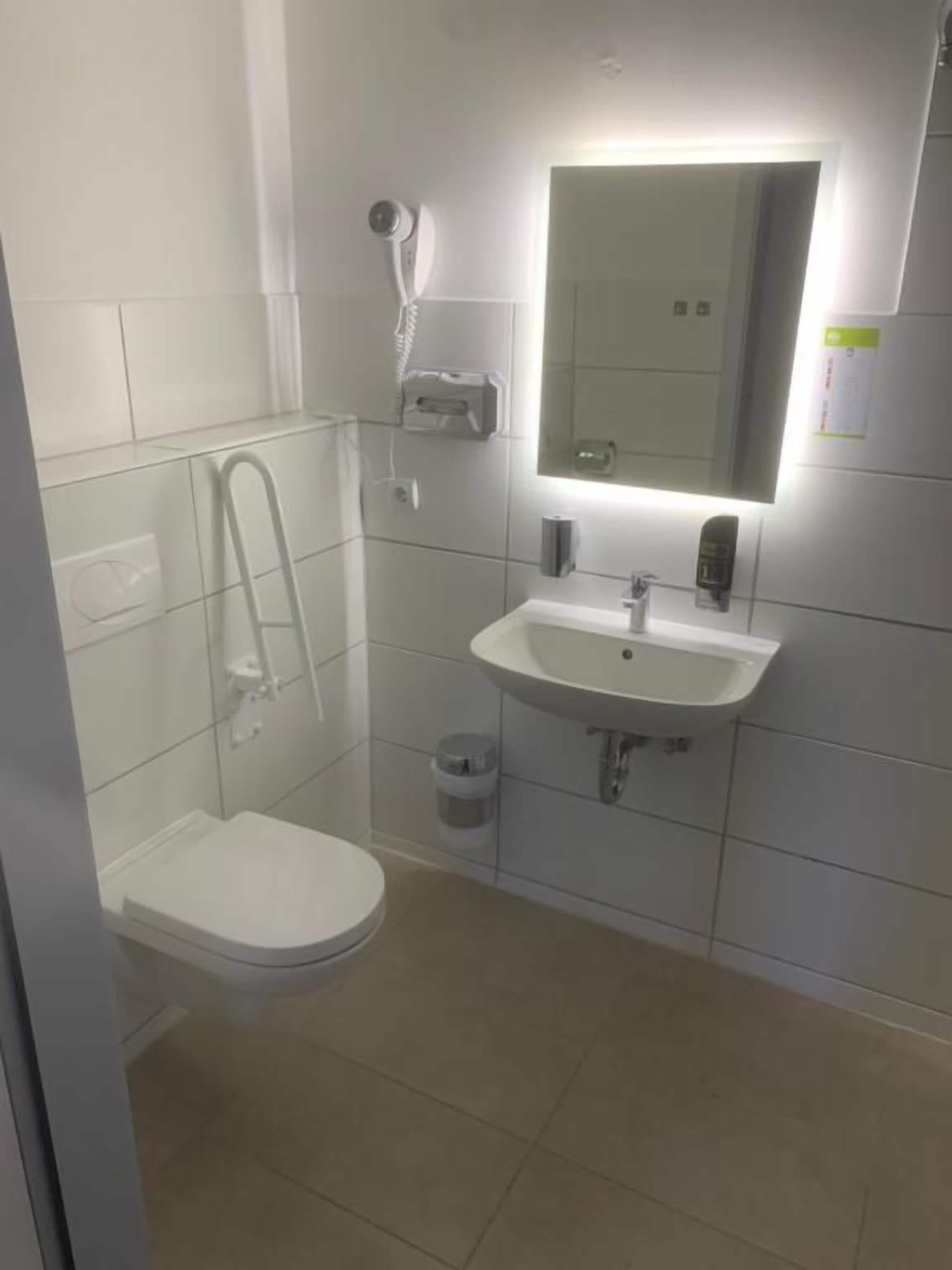 A bathroom with a toilet, sink, and shower.