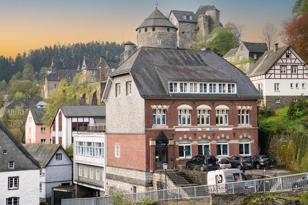 A hotel with a traditional European architectural style, featuring a prominent tower and a stone facade.