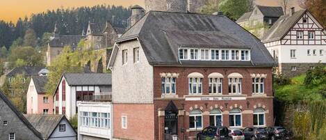 Un hotel de estilo arquitectónico europeo tradicional, con una torre destacada y fachada de piedra.