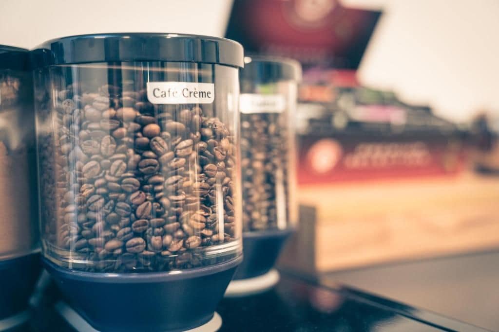 A coffee bean dispenser with a label reading 'Cafe Creme.'