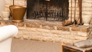 A stone fireplace with a hanging sign, a brass pot, and antique candle holders. - Relax near the water slides Kalahari Waterpark Resort - 14 mins (Sandusky)