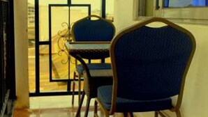 Une chambre avec un balcon, une table et une chaise.