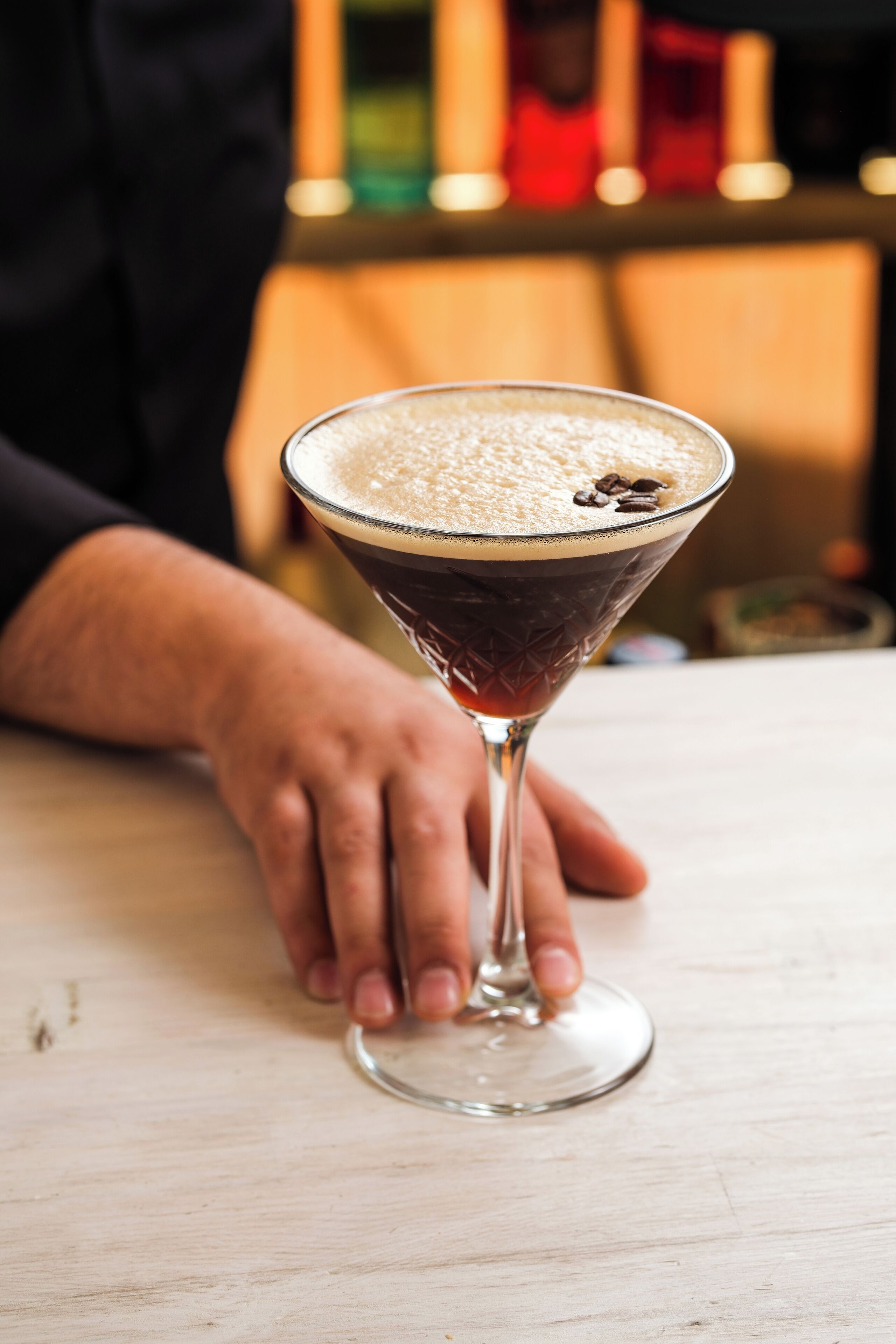 Un verre à martini avec une mousse onctueuse, posé sur une surface en bois.
