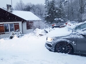 A residential area with a house and parked cars covered in snow. - Homerez - Studio in Gérardmer (Gérardmer)